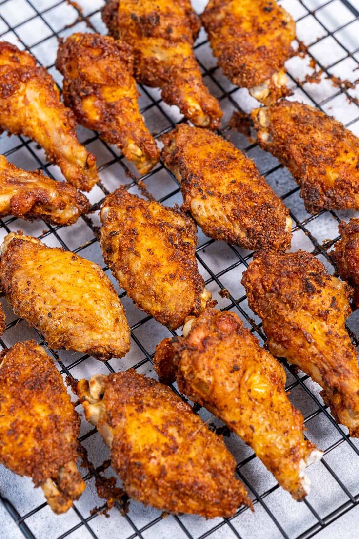 fried chicken wings on a cooling rack ready to be cooked in the oven for consumption