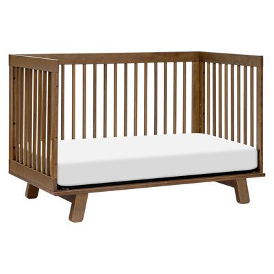 a wooden crib with a white mattress on it's bottom and side rails