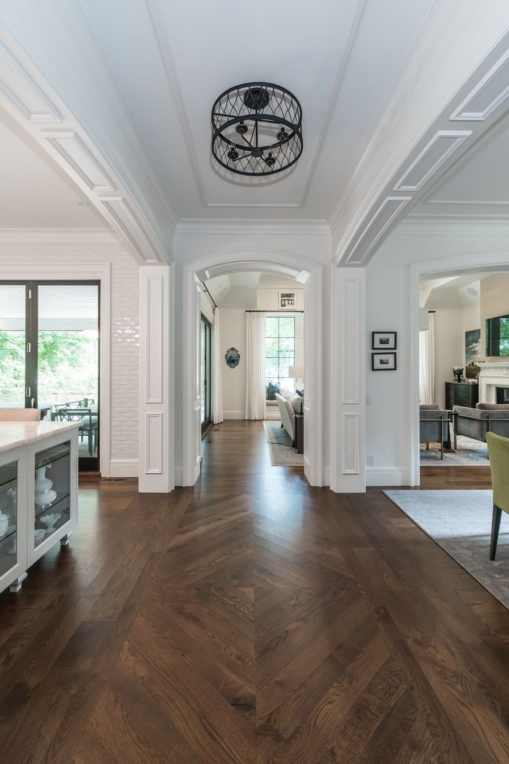 a large open living room with wood floors and white trimmings on the walls