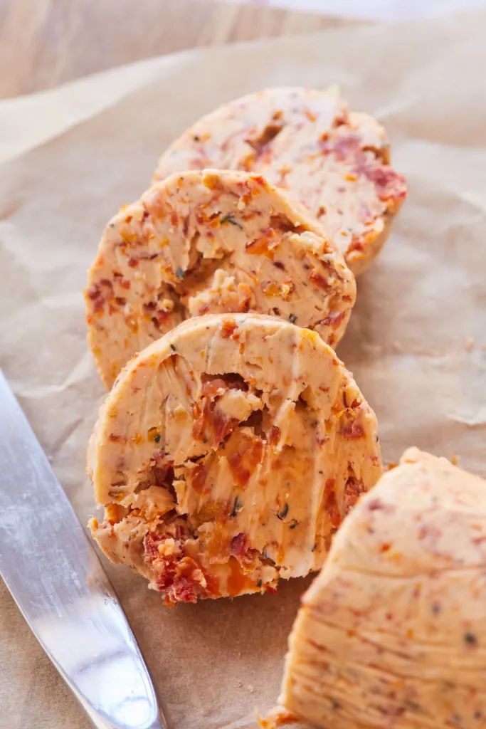 three pieces of pizza sitting on top of a piece of wax paper next to a knife