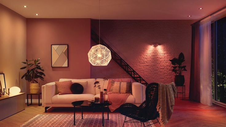 a living room filled with furniture next to a fire place and a staircase leading up to the second floor