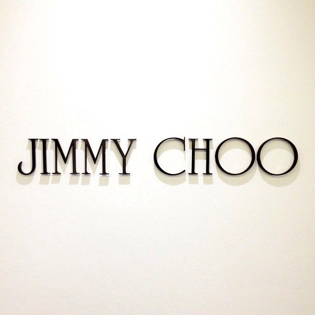 the jimmy choo sign is mounted on the wall in front of a white wall