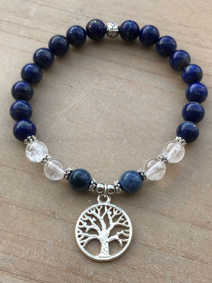 Spiritual Awareness Bracelet, Lapis Lazuli Bracelet, Dumortierite Bracelet, Clear Quartz Bracelet This beautiful bracelet is made of 8mm Lapis Lazuli beads, 8mm Dumortierite beads, 8mm Clear Quartz beads, silver flower spacers, silver spacers and it is adorned with an adorable Tree of Life pendant. The bracelet shown fits to 7.5 inches wrist but you can choose your own wrist size. Clear Quartz *All chakras *Works on all levels of being *Stores information like a natural computer which can be acc Natural Lapis Lazuli Bracelets, Lapis Lazuli Bracelets For Meditation, Symbolic Blue Bracelet Jewelry, Adjustable Lapis Lazuli Crystal Bracelet Gift, Lapis Lazuli Gemstone Beads Bracelets As Gift, Silver Lapis Lazuli Bracelet, Hand-strung, Lapis Lazuli Bracelet For Meditation, Silver Lapis Lazuli Hand-strung Bracelets, Silver Hand-strung Lapis Lazuli Bracelet