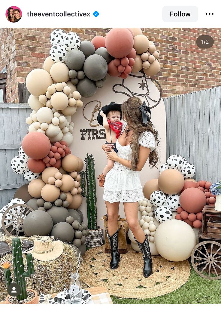 a woman standing in front of a balloon arch