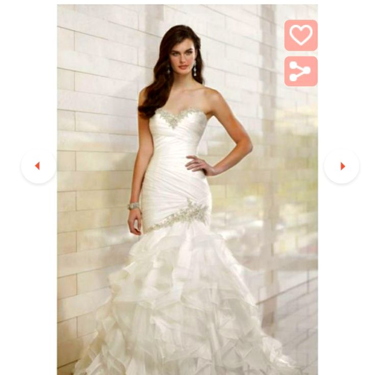 a woman in a white wedding dress standing next to a brick wall