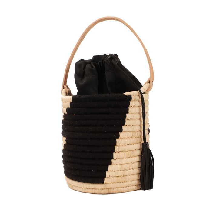 The Coba Basket Bag is the perfect carry-all for your personal items or toting a favorite bottle of rose' to the beach. The tote has a natural leather handle, a black cotton drawstring lining to secure your belongings and is finished off with a black leather tassel. It's natural style all the way from city to beach. Made from raffia, nylon and cow leather Measures: 7"H 6"W (not including handle) Black Travel Shoulder Bag With Bamboo Handle, Black Shoulder Bag With Bamboo Handle For Travel, Black Bucket Straw Bag For Vacation, Beach Bucket Bag With Top Handle And Removable Pouch, Beach Bucket Bag With Removable Pouch And Top Handle, Chic Black Bag With Bamboo Handle, Black Leather-handled Bucket Bag, Black Leather Bucket Bag With Leather Handles, Black Bucket Straw Bag