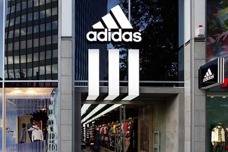 adidas store front with people walking in the doorway