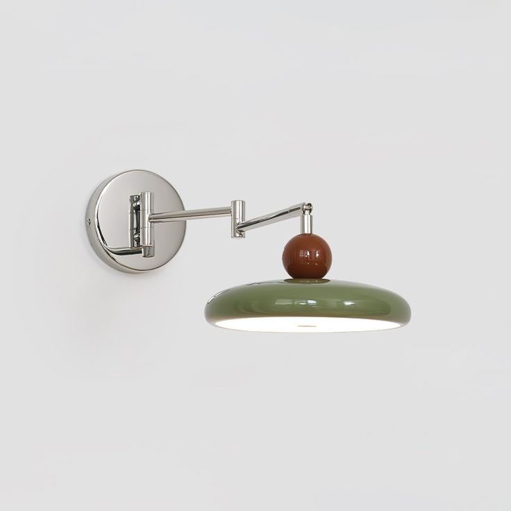 a wall mounted light with an apple on the top and a green lamp below it