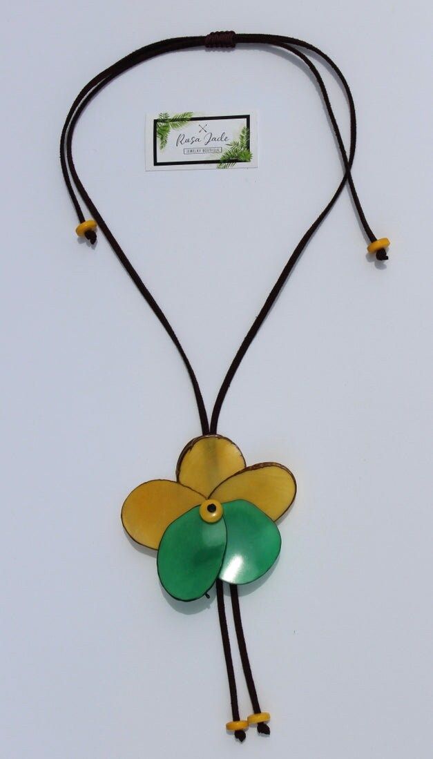 Handmade in Ecuador Necklace Length: 15 -35.5 Adjustable Length Material: Tagua Nut Handmade Clasp Due to this item being handmade and the nature of the Tagua Nut the size and the color may vary from piece to piece Yellow Flower Necklace For The Beach, Yellow Flower Necklace For Beach, Bohemian Brown Flower Necklace, Handmade Adjustable Flower Necklace For Beach, Handmade Flower Pendant Jewelry For Beach, Handmade Flower Pendant Necklace For Beach, Nature-inspired Brown Flower-shaped Jewelry, Adjustable Artisan Flower Necklace, Artisan Flower Necklace With Adjustable Fit