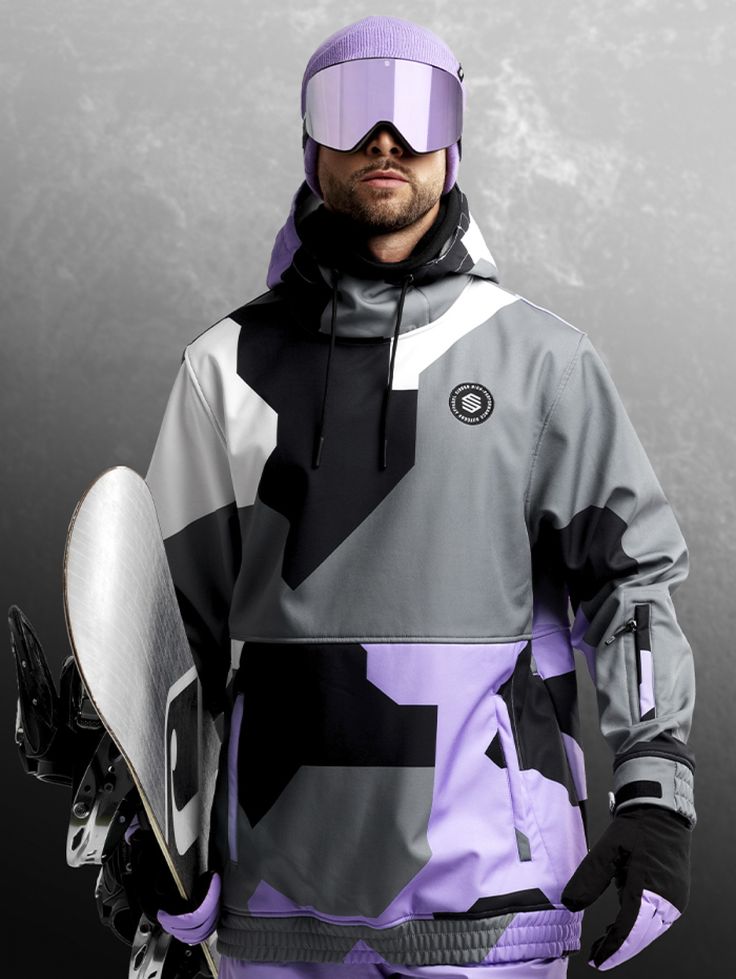 a man in ski gear holding a snowboard