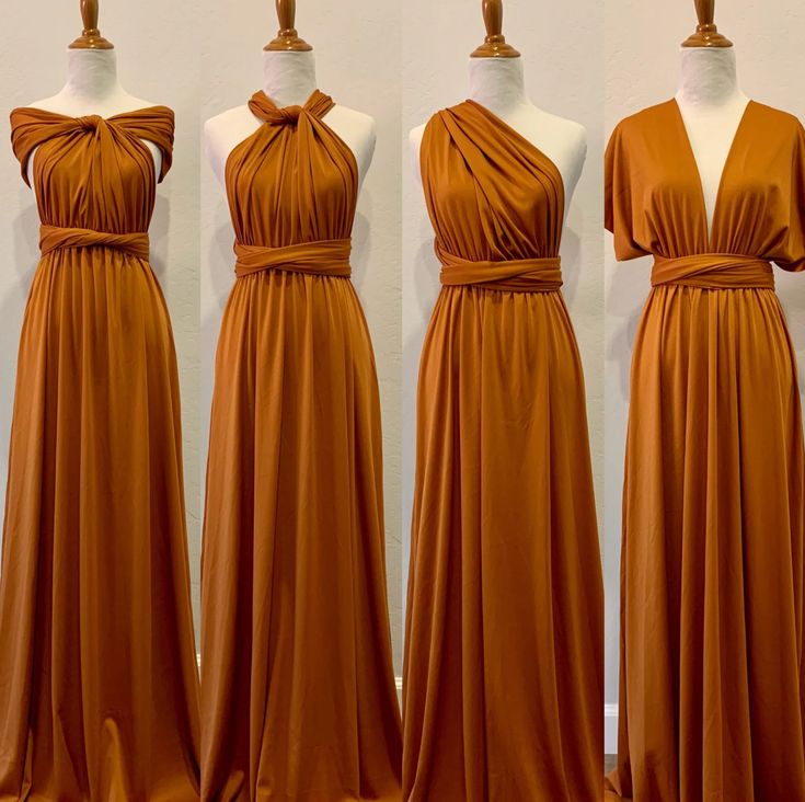 three dresses on mannequins in front of a white wall and one is wearing an orange dress