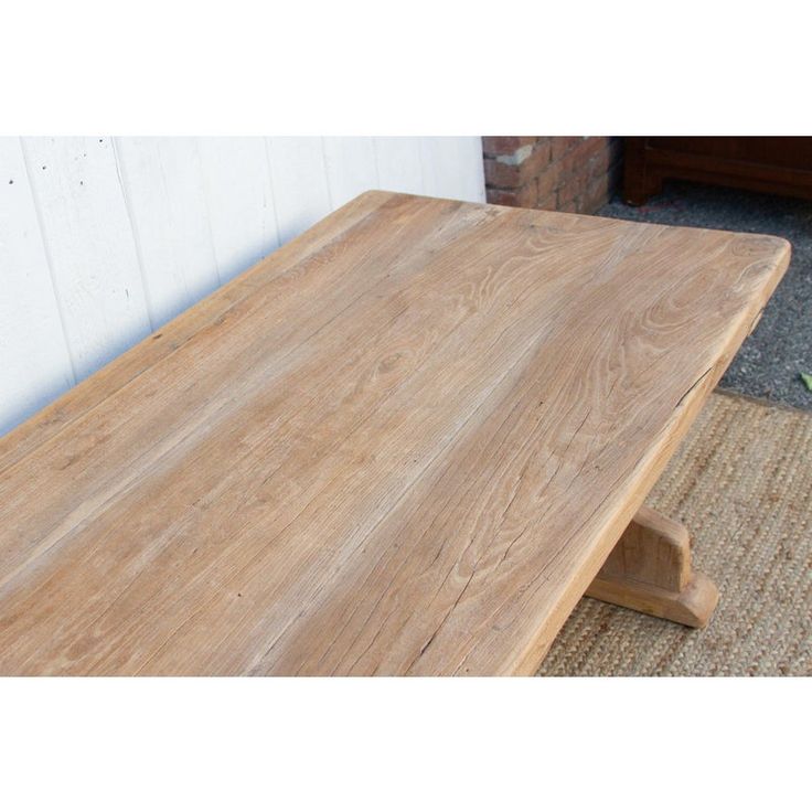 a wooden table sitting on top of a rug next to a white wall and door