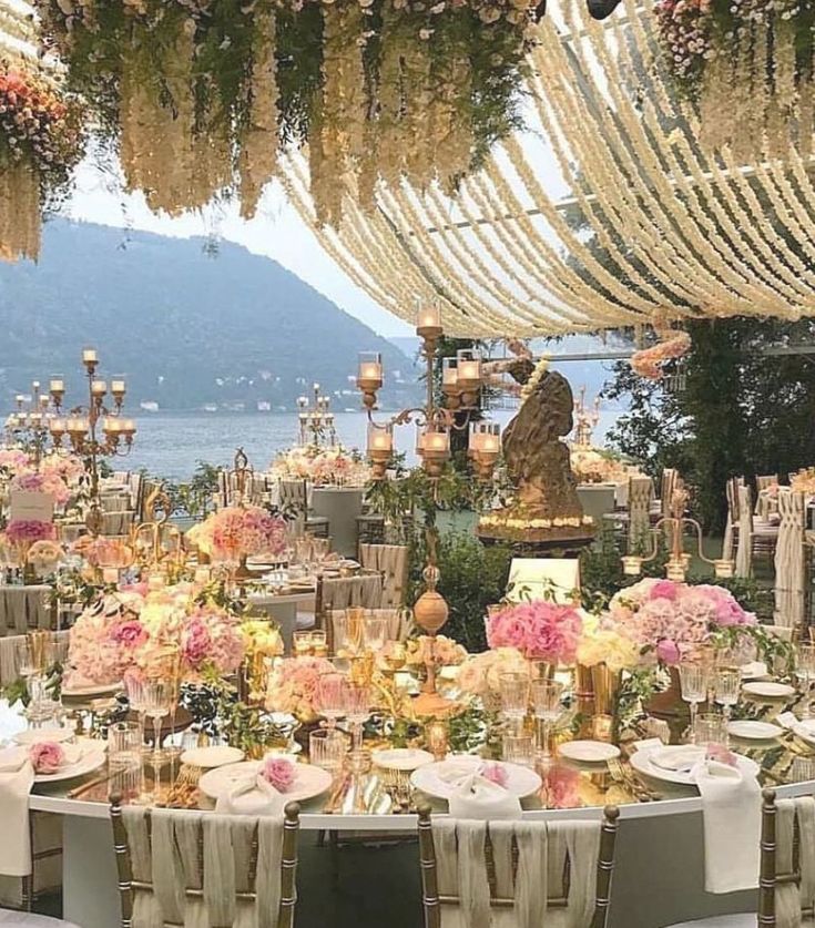 an outdoor dining area with tables and chairs set up for a formal function on the water