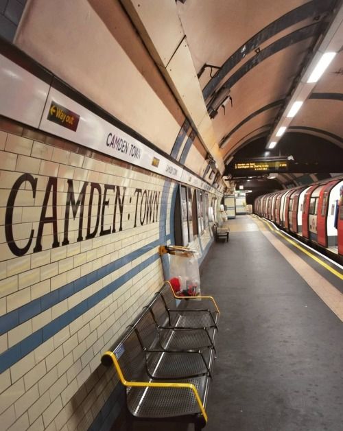 a subway station with benches and signs on the wall that read camden - toul