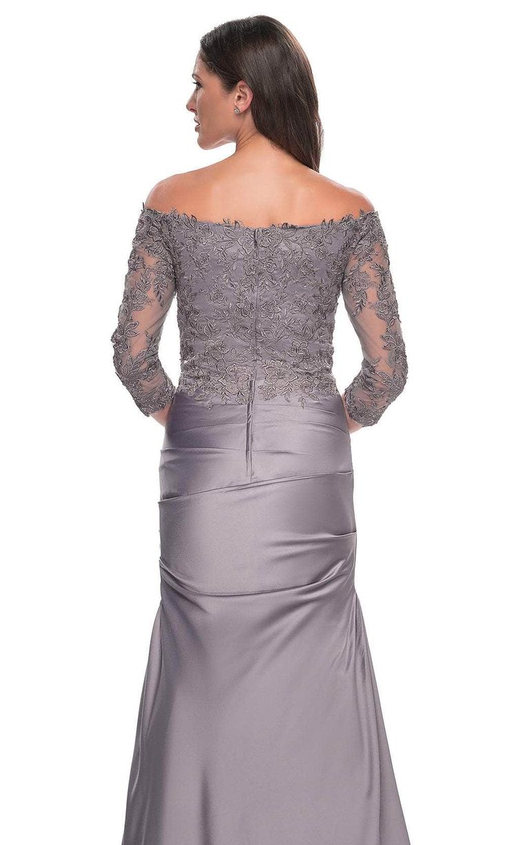 Make a striking impression at the event in the stunning La Femme 30853 creation. Exquisitely tailored with precision to enhance the feminine silhouette, this dress showcases an off-the-shoulder neckline atop a pleat-ornate satin silhouette. Sheer quarter sleeves adorned with lace details add a touch of elegance, while the full back design features a zipper closure for a seamless fit. The trumpet skirt is meticulously sculpted to flatter and flares gracefully into a sweep train, adding a hint of Elegant Off-shoulder Mother Of The Bride Dress For Gala, Off-shoulder Mother Of The Bride Dress For Gala, Fitted Boat Neck Evening Dress For Gala, Boat Neck Evening Dress With Fitted Bodice, Elegant Off-shoulder Dress With Sweep Train, Elegant Off Shoulder Boat Neck Evening Dress, Gala Off-shoulder Evening Dress With Fitted Bodice, Wedding Dress With Fitted Bodice And Boat Neck, Elegant Off-shoulder Boat Neck Evening Dress