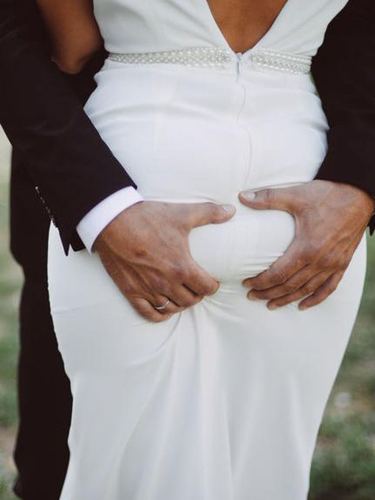 a man and woman in wedding attire holding hands on each other's butts