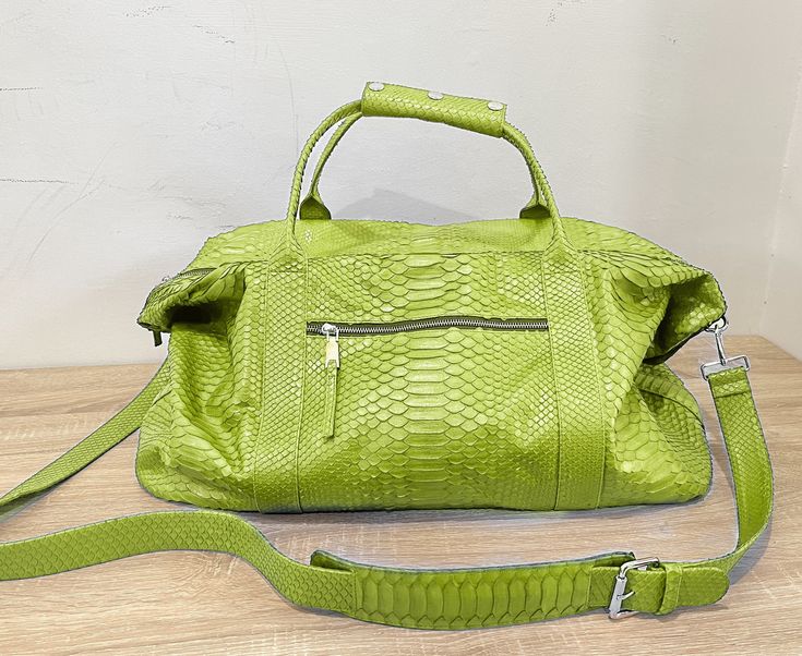 Indulge in the exquisite craftsmanship of our handmade SNAKESKIN Weekender/Duffle bag.  With a focus on premium quality, this travel companion boasts a removable shoulder strap for added convenience, making it equally appealing to both men and women. Dimensions: - Width: 55 cm/21.6 in - Height: 36 cm/14.1 in - Depth: 24 cm/9.4 in Inside, discover a thoughtfully designed interior with a handy zipper pocket. Our commitment to perfection is evident in the rigorous testing each new model undergoes a Luxury Green Shoulder Bag For Travel, Luxury Green Travel Bag For Everyday Use, Luxury Green Travel Bag For Daily Use, Luxury Travel Bag For Weekend Trips, Luxury Shoulder Bag With Detachable Strap For Weekend Trips, Luxury Weekender Bag With Removable Pouch, Luxury Travel Bag With Removable Pouch For Trip, Luxury Shoulder Bag With Removable Pouch For Weekend Trips, Luxury Shoulder Bag With Removable Pouch For Trips