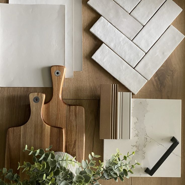 cutting board, knife and papers laid out on top of a wooden table with plants