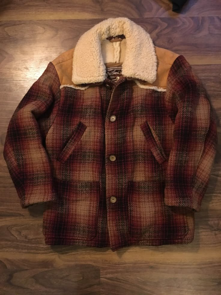 a jacket with a fur collar on top of a wooden floor