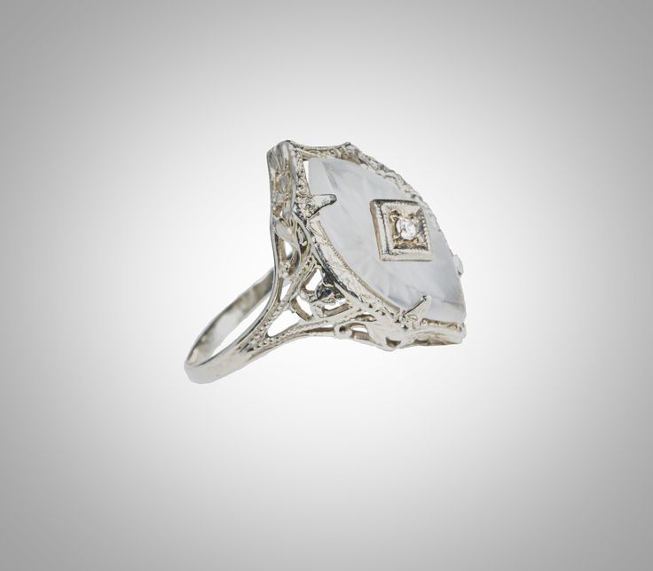 "Art Deco 14k diamond camphor glass ring in very fine condition. Unusual navette shaped camphor glass crystal set with a 2 mm European cut diamond. 7/8\" wide head 3.8 gram total" Formal Diamond Ring With Intaglio, Antique Diamond Intaglio Jewelry, Vintage White Marquise Ring, White Signet Ring With Diamond Accents For Wedding, White Diamond Accented Signet Ring For Wedding, White Hallmarked Diamond Ring Collectible, Vintage White Marquise Cut Rings, Vintage White Marquise Jewelry, Art Deco White Jewelry With Rose Cut Diamonds