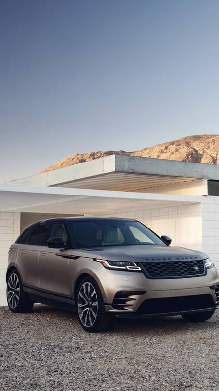 the new range rover is parked in front of a house with mountains in the background