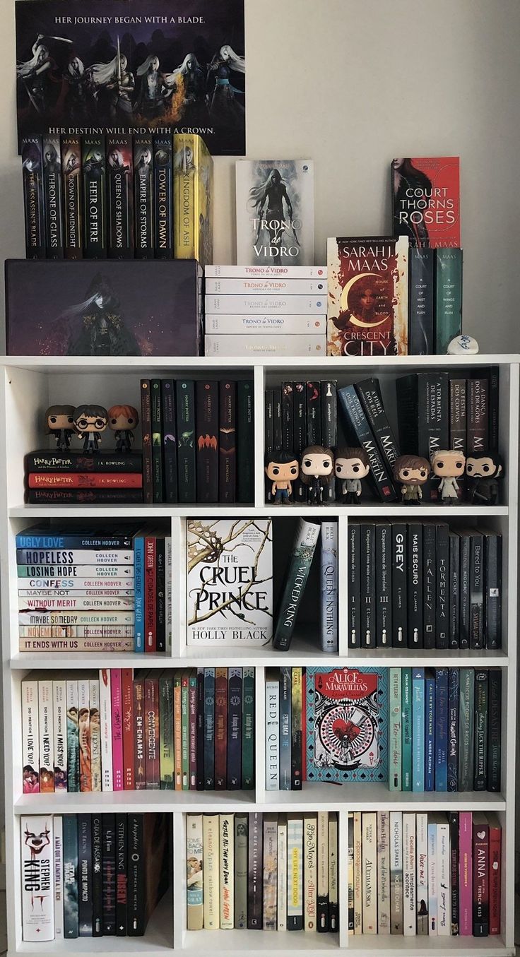 a bookshelf filled with lots of books next to a wall mounted movie poster