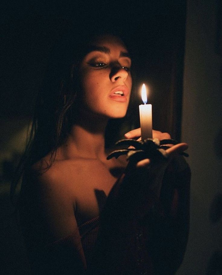 a woman holding a lit candle in her hand