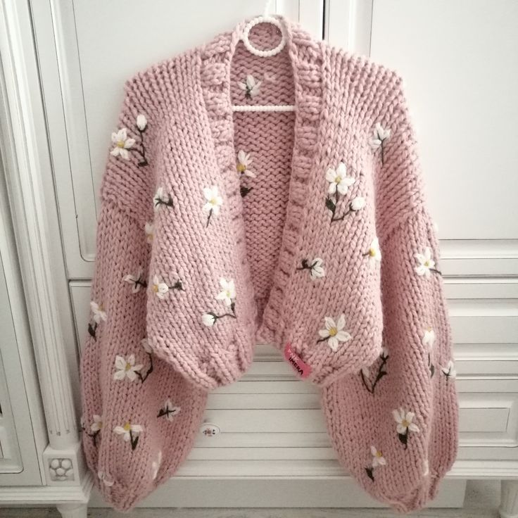 a pink cardigan sweater with flowers on it