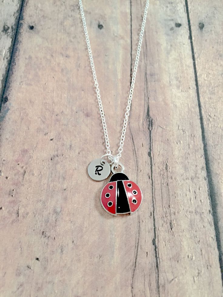 "This listing is for a hand-stamped initial necklace featuring a 7/10\" x 1/2\" silver plated and red enamel ladybug charm & 3/10\" stainless steel initial pendant. The silver plated chain is 18\" long, but can be made to your desired length- see last photo in listing for length guide. Please indicate the chain length you would like in the 'notes to seller' section at checkout. All items are lead & nickel free. Message me with any questions, thank you! Add an initial to any necklace http Red Charms Jewelry For Birthday, Cute Round Red Jewelry, Cute Red Round Jewelry, Dainty Red Personalized Charm Necklaces, Dainty Personalized Red Charm Necklaces, Dainty Red Personalized Necklaces, Red Personalized Dainty Necklace, Dainty Personalized Red Necklaces, Personalized Red Dainty Necklace