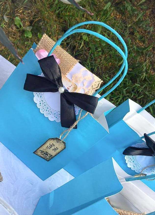 blue paper bags with black bows and tags on them