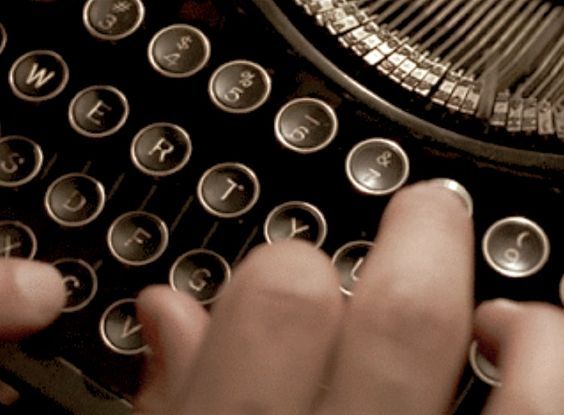 someone typing on an old fashioned typewriter with their hands and thumbnails touching the keys