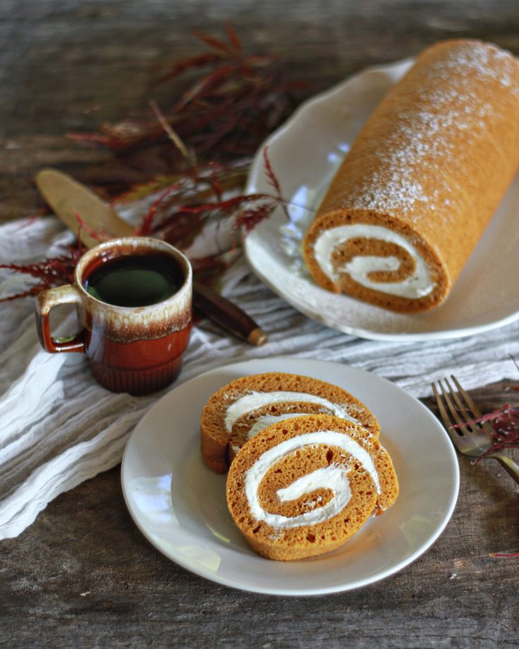 two white plates topped with cinnamon rolls next to a cup of coffee