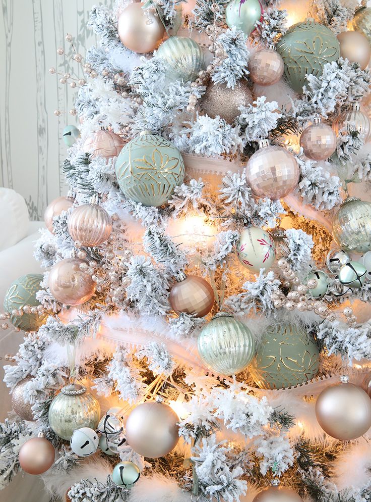 a white christmas tree with silver and gold ornaments