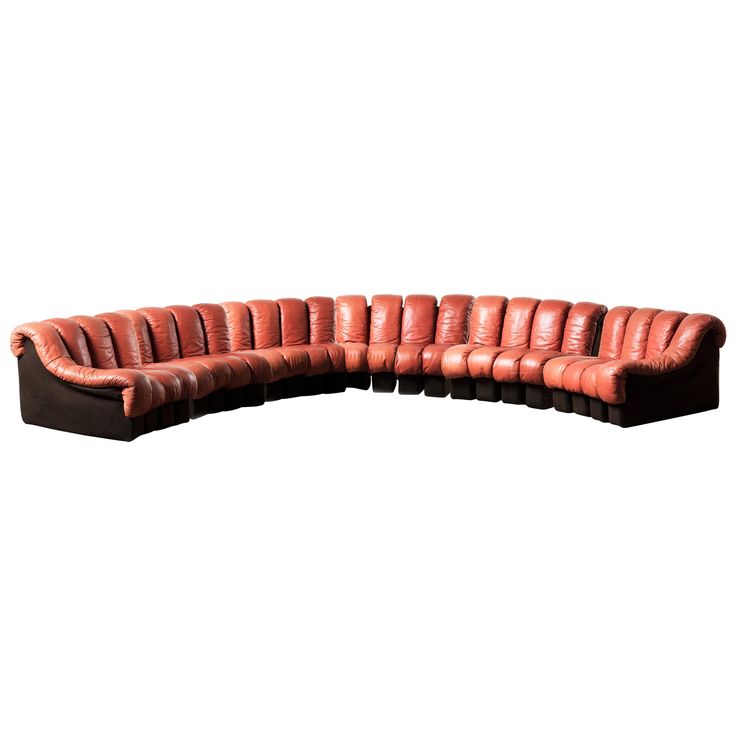 a curved leather couch with black legs