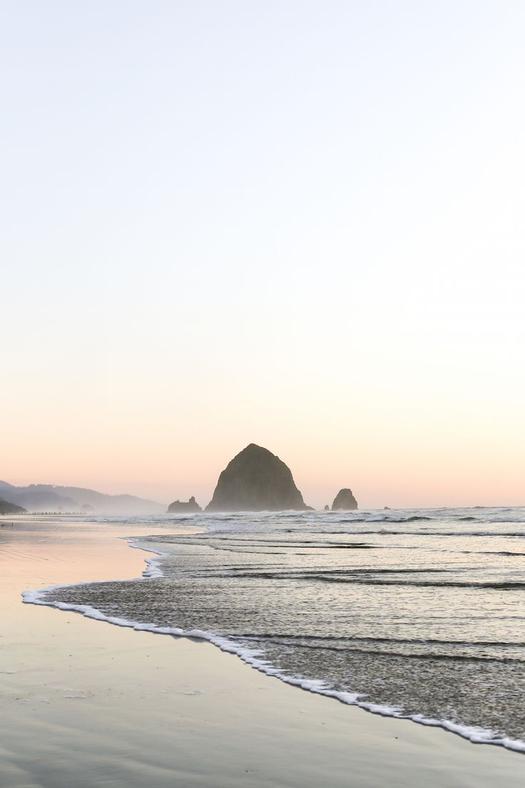 two people walking on the beach at sunset