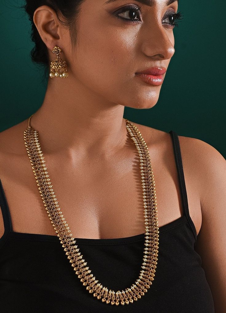 This elegant Antique Gold Plated Long Necklace Set features a beautifully crafted layered necklace paired with matching earrings. The necklace's intricate design and the earrings’ delicate detailing make it perfect for traditional or formal occasions. Ideal for adding a touch of sophistication to any outfit, this set is a timeless addition to your collection. The necklace measures by 38 inches, and earrings by 4.5 inches in lengthComposition : Mixed Metal with other Semi Precious StonesCare: Keep away from water and perfume Delivery : 2-4 weeks as the product is hand crafted. For more information and sizes please contact fabiliciousfashion@gmail.com or visit our Copenhagen studio. About the Designer : Zaza by Somya is a thoughtfully curated collection of bold yet feminine jewelry pieces. H Elegant Brass Kundan Chandbali Necklace, Elegant Kundan Chandbali Necklace In Brass, Elegant Chandbali Kundan Necklace In Brass, Elegant Brass Kundan Necklace For Celebration, Elegant Kundan Necklace For Celebration, Elegant Brass Jewelry Sets For Celebration, Elegant Hand Set Brass Necklace, Elegant Dual-tone Kundan Jewelry Sets, Elegant Hand-set Brass Necklaces