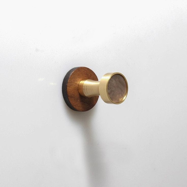 a door knob with a wooden handle on a white wall