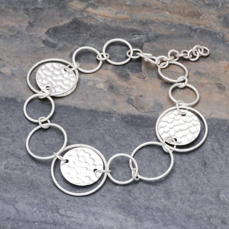 This stylish 950 silver link bracelet is presented by Pakaon Sojintarit who works with artisans of the Karen hill tribe in Thailand. Hammered discs join forces with polished round links in assorted sizes. The result is a fun contemporary accessory to wear anywhere. Modern Silver Hammered Bracelets, Modern Hammered Silver Bracelets, Modern Silver Round Chain Bracelet, Modern Hammered Sterling Silver Bracelets, Modern Round Jewelry With Unique Variations, Modern Round Sterling Silver Bracelets, Sterling Silver Polished Round Bracelet, Sterling Silver Hammered Bracelets, Hammered Sterling Silver Round Bracelets