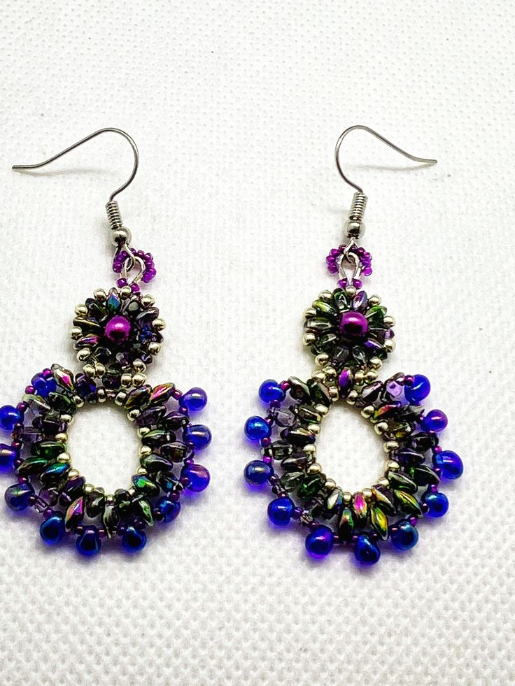 These beautiful, one of a kind, earrings were hand stitched using a variety of pink, purple, and silver Czech beads. They were created using pink pearls, iris super and mini duos, purple drops, and silver and purple seed beads. The result is a unique and festive pair of earrings that are perfect for a formal event or to dress up an everyday ensemble. They hang from hypo allergenic ear wires and come carded with stoppers Handmade Teardrop Beaded Earrings For Parties, Handmade Pearl Drop Earrings For Party, Handmade Multicolor Pearl Earrings Gift, Handmade Multicolor Pearl Earrings For Gift, Elegant Handmade Iridescent Beaded Earrings, Multicolor Handmade Pearl Earrings For Gift, Elegant Handmade Iridescent Earrings, Handmade Iridescent Round Bead Earrings, Handmade Iridescent Earrings With Round Beads