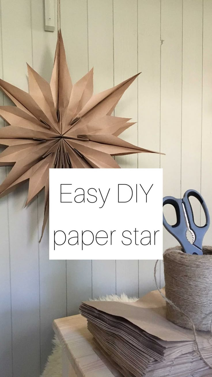 a paper star hanging from the side of a wall next to some scissors and papers