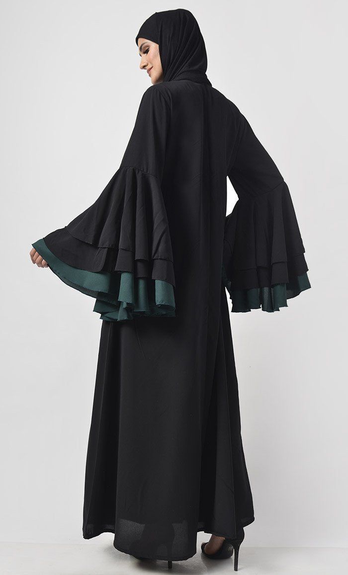 Defined by its dramatic silhouette, this piece sprinkle class add a touch of trend to your black-only wardrobe Round neck Knife pleats on princess seam Multi layer flare sleeves FABRIC: Nida CARE: Machine wash cold Our Model Is Wearing Size 'S' Black Long Sleeve Abaya For Fall, Black Long Abaya For Spring, Long Black Abaya For Spring, Spring Black Long Abaya, Long Black Spring Abaya, Spring Black Maxi Length Abaya, Spring Black Maxi-length Abaya, Modest Fitted Black Abaya, Fitted Long Sleeve Black Abaya