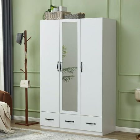 a white armoire in a room with green walls