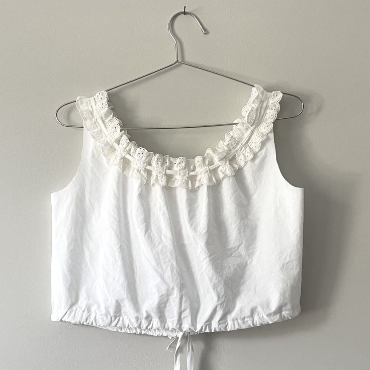 White Cotton Tank Top With Tie Back, White Cotton Top With Drawstring Tie, White Cotton Tops With Drawstring Tie, Sleeveless Cotton Eyelet Top, White Sleeveless Top With Eyelet Details, White Sleeveless Eyelet Top, White Tops With Tie Straps For Daywear, White Tie Strap Tops For Daywear, White Tie Straps Tops For Daywear