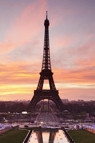 the eiffel tower is lit up at sunset