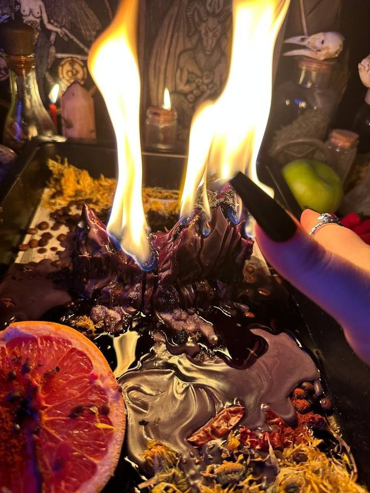 a person holding a cell phone in front of a fire