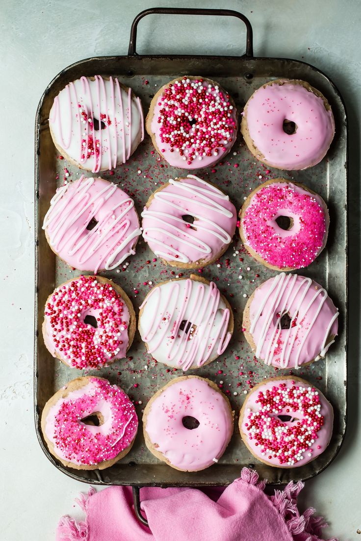 pink frosted donuts with sprinkles in a tray