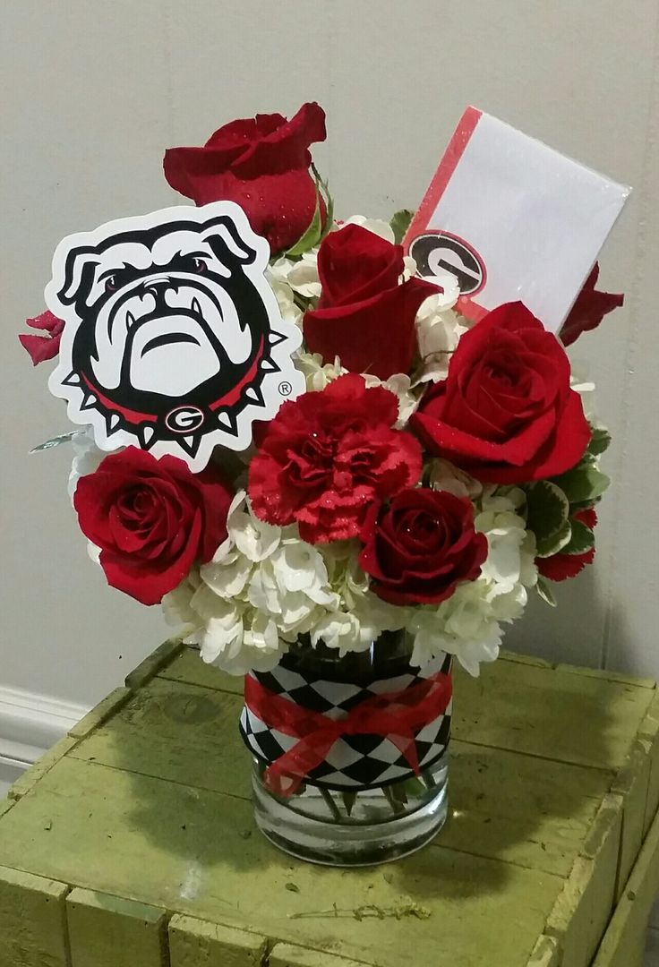 a vase filled with red roses and white flowers