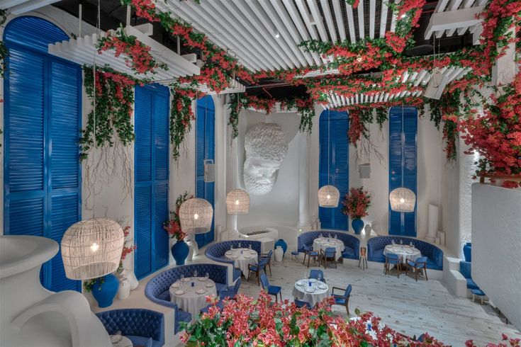 the interior of a restaurant with blue and white walls, flowers on the ceiling, and chandeliers hanging from the ceiling