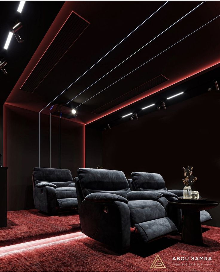 a red carpeted room with two recliners and a table in the middle