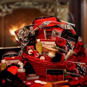 a red basket filled with lots of valentine's day gifts for her on top of a table